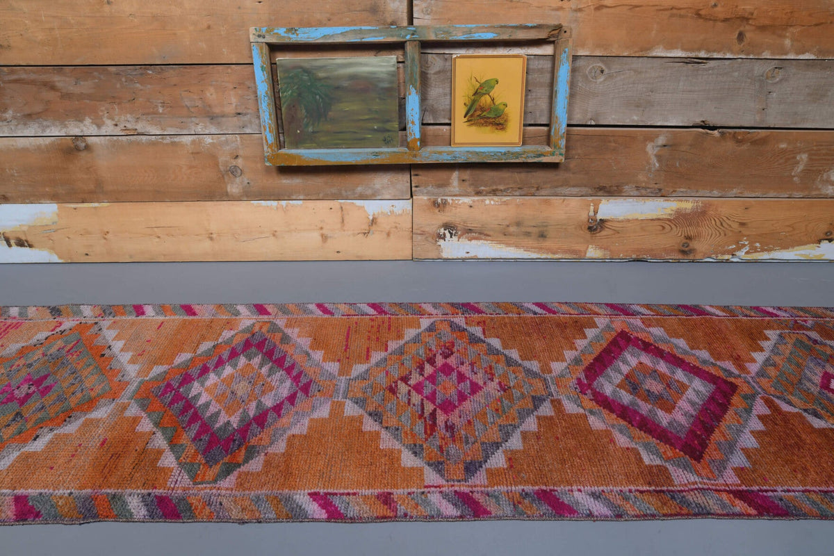 Ikat desenli el dokuma vintage yolluk – kırmızı, turuncu ve pembe tonlarda yün dokuma